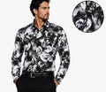 A man wearing a long-sleeve button-up shirt with a black and white floral print, paired with black trousers and a black belt. A circular inset in the top right shows a close-up of the fabric's detailed floral pattern.